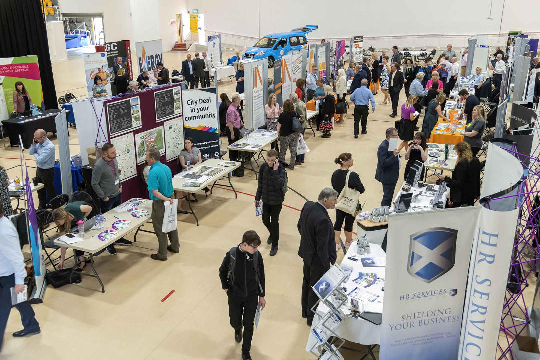 Image of company stands at a chamber event with people walking around